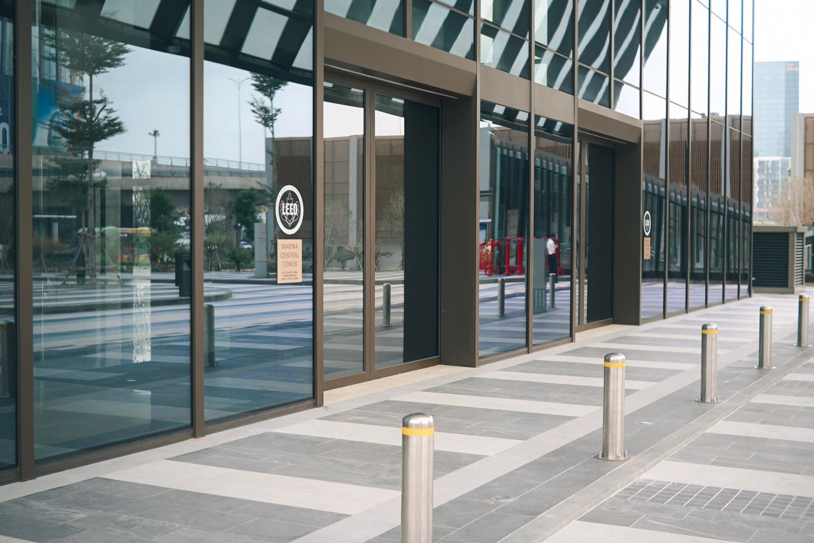 Sleek modern building exterior featuring glass windows and vertical pillars in a contemporary urban setting.